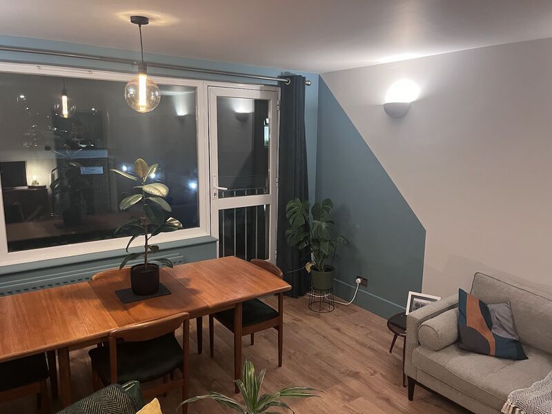 Dining room with a blue-green painted wall and a wooden table